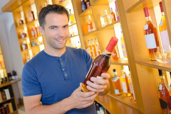 Schöner junger Mann bei der Auswahl edler Weine — Stockfoto