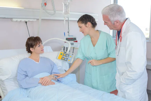 Enfermeira tranquilizadora paciente na cama do hospital — Fotografia de Stock