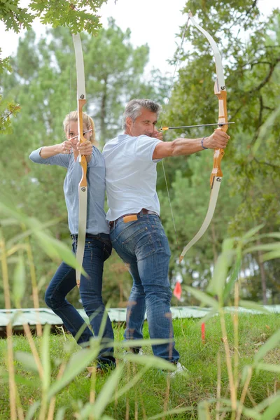 Uomo e donna schiena a schiena con arco e frecce — Foto Stock