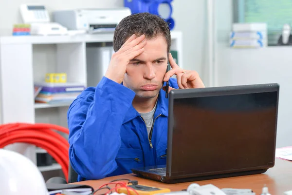 Homem frustrado ao telefone, olhando para o computador — Fotografia de Stock