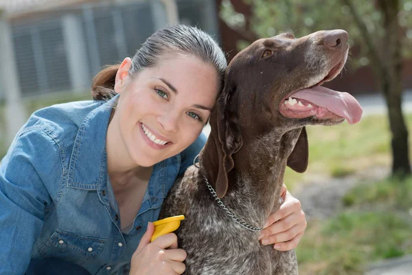 Vétérinaire femelle caressant chien à l'abri des animaux — Photo