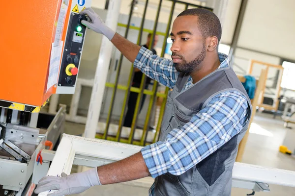 Trabajador activando maquinaria y trabajador — Foto de Stock