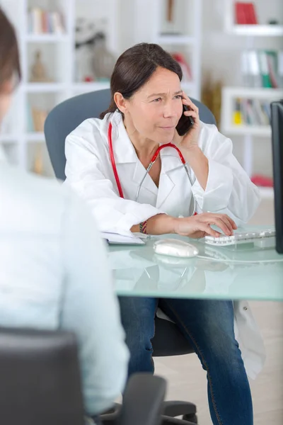 Arts op de telefoon roepen analyseert centrum met patiënt — Stockfoto