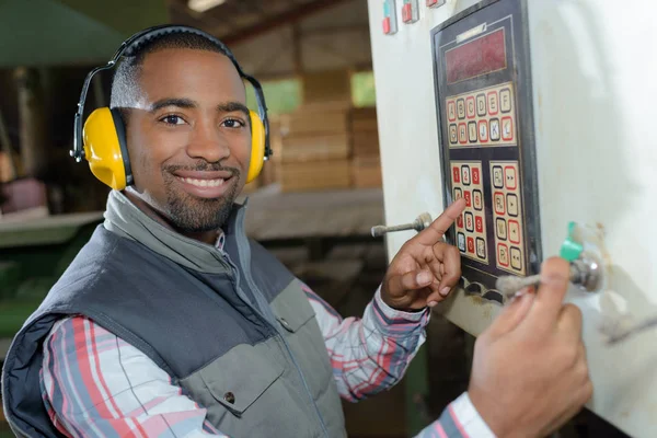 Worker pointing at a machine button — Stock Photo, Image