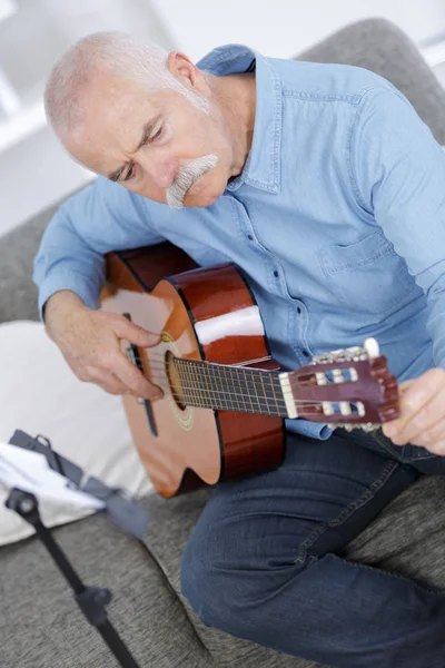 Portret van senior man akoestische gitaar spelen — Stockfoto