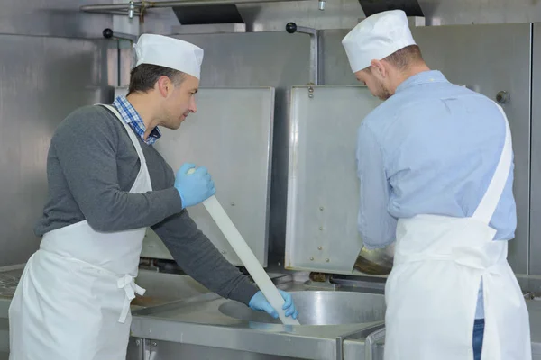 Lehrling und Chef bereitet in Restaurantküche Fleisch zu — Stockfoto