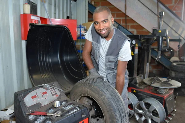 Trabalhador consertar um pneu — Fotografia de Stock