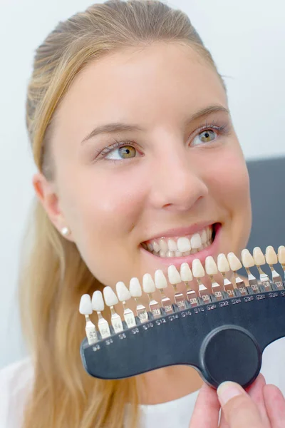 Молодая женщина выбирает зубные протезы — стоковое фото
