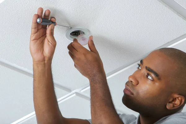 Trabalhador instalando um detector de fumaça em uma sala — Fotografia de Stock