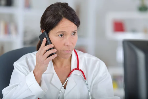 Krásná doktor mluvil po telefonu v nemocnici — Stock fotografie