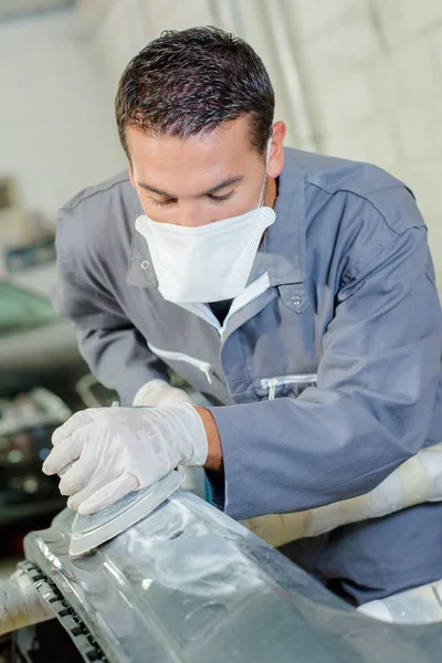 Young mechanic polishing a bodywork — Stock Photo, Image