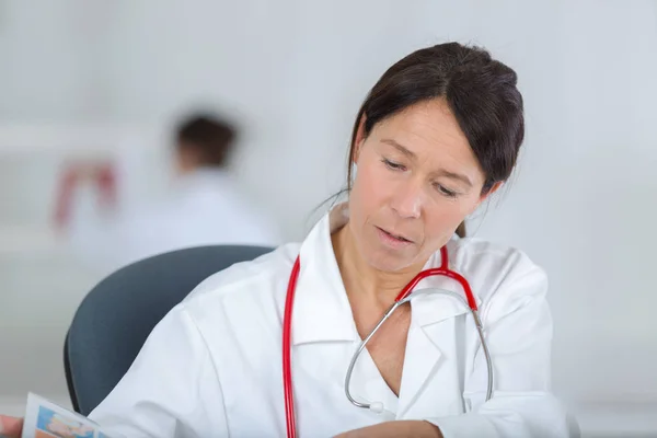 Donna stressata medico seduto nel suo ufficio — Foto Stock