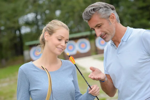 Homme et femme regardant les flèches de tir à l'arc — Photo