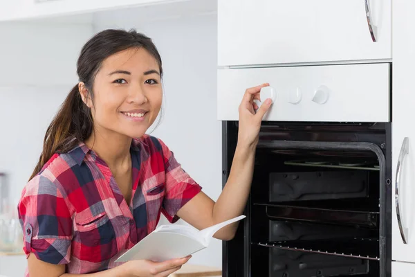 Mujer con cocina nueva y manual de instrucciones — Foto de Stock