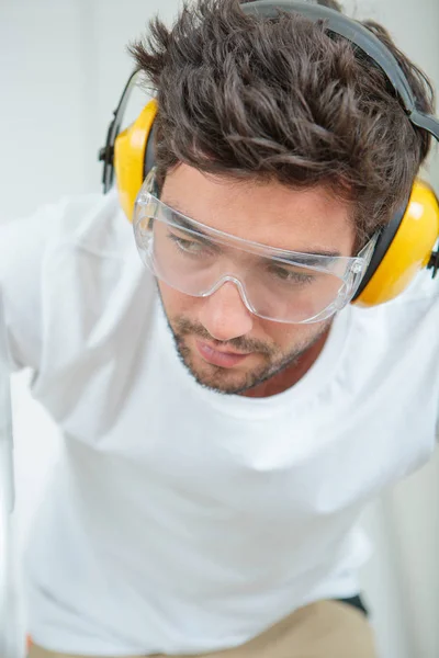 Homem usando óculos e protetores auriculares — Fotografia de Stock