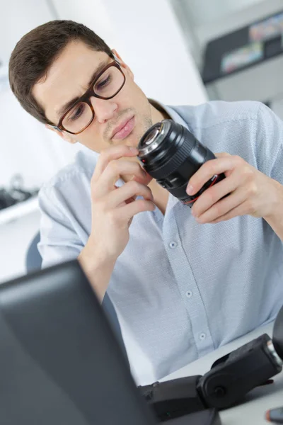 Fotógrafo soldar disparador flash sem fio em seu local de trabalho Fotografia De Stock