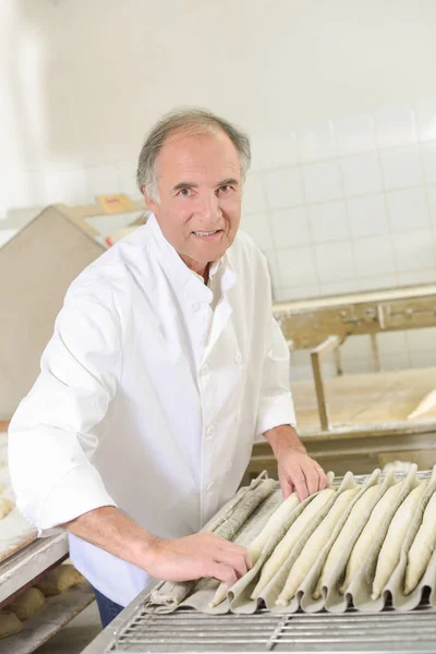 Panadero de masa rodante en baguettes —  Fotos de Stock