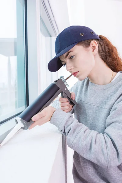 Mujer usando pistola de calafateo —  Fotos de Stock