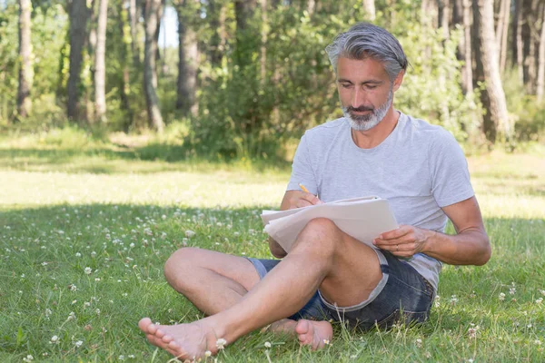 Bellissimo uomo pittura un paesaggio primaverile — Foto Stock