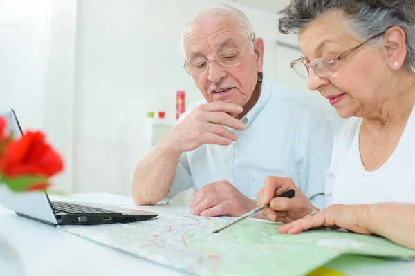 Pareja de ancianos mapeando la ruta — Foto de Stock