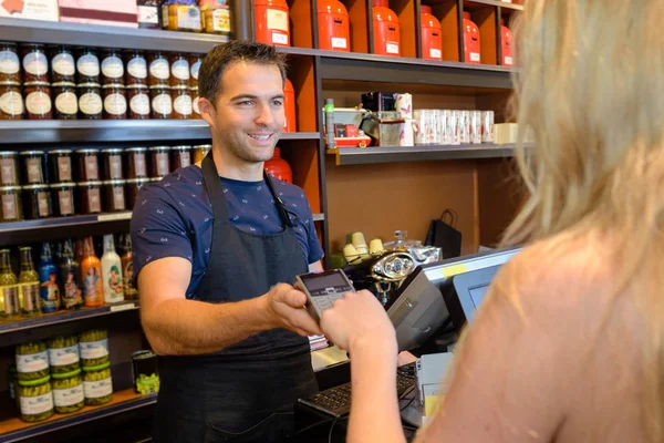 Cliente ingresando código en un dispositivo de pago en una tienda — Foto de Stock