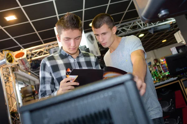 Unga män i musikstudio tittar på häfte — Stockfoto