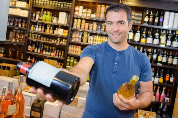 Schöner junger Mann bei der Auswahl edler Weine — Stockfoto