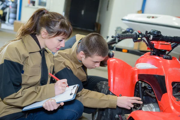 Giovani meccanici esaminando quadbike — Foto Stock