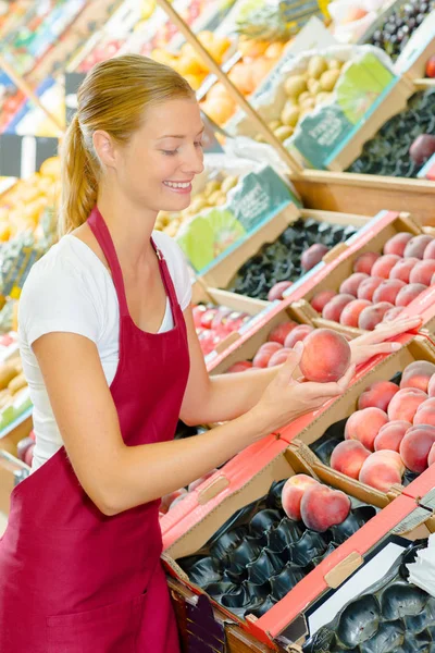 Young shop assistant taking care of her stand — Stock Photo, Image