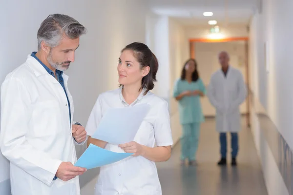 Médicos conferidos en corredor hospitalario — Foto de Stock