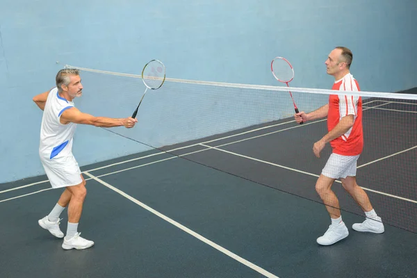 Homens jogando badminton e badminton — Fotografia de Stock