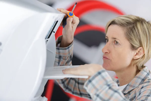 Sarışın temizlikçi kadın havalandırma sistemini tamir ediyor. — Stok fotoğraf