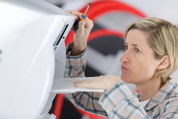 Blond handywoman rengöring fastställande ventilationssystem — Stockfoto