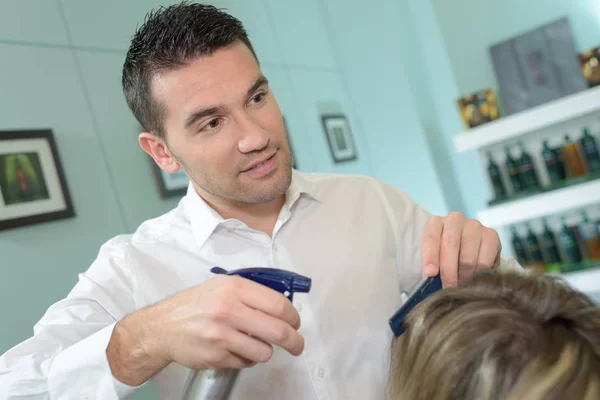 Peluquería masculina rociando el cabello del cliente — Foto de Stock
