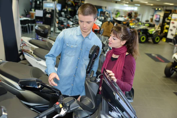 Pareja joven mirando scooter — Foto de Stock