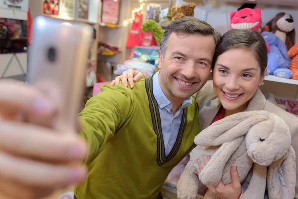 Föräldrar-till-vara shopping välja plysch för sitt barn — Stockfoto