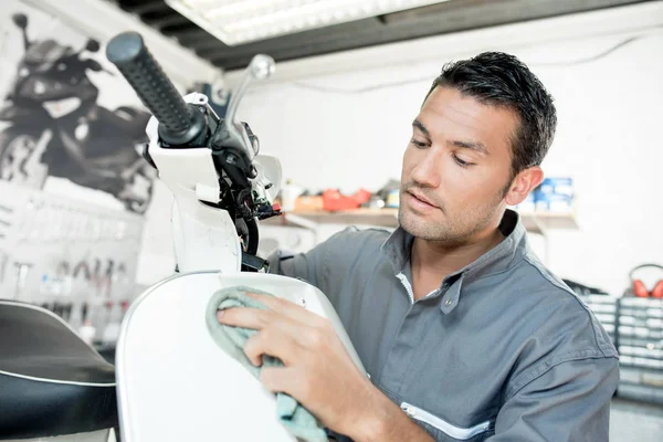 Mechaniker putzt einen Motorroller — Stockfoto