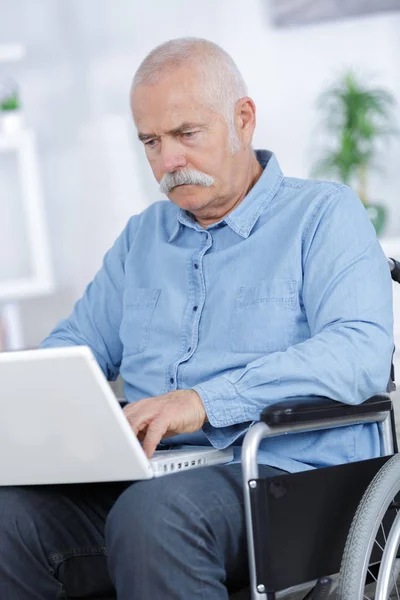 Disabled Senior Man Sentado em cadeira de rodas usando laptop — Fotografia de Stock