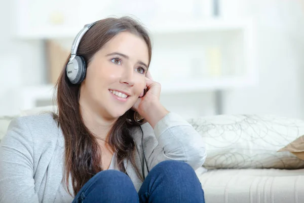 Giovane e sorridente donna che ascolta musica — Foto Stock