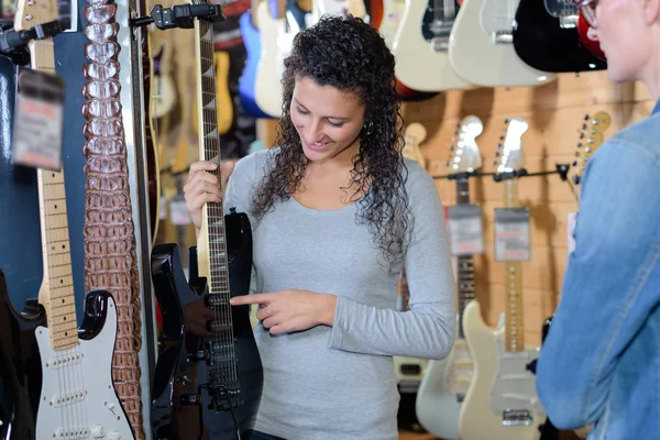 Musiker wählt E-Gitarre im Musikladen — Stockfoto