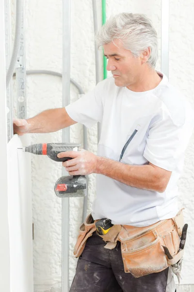 Costruttore drilling hole in wall — Foto Stock