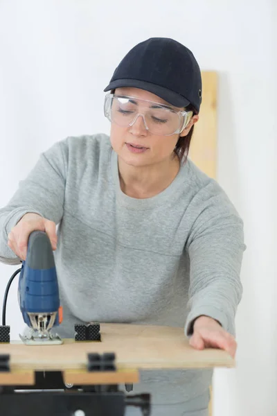 밴드와 함께 작업 하는 여성 목수를 보았다 — 스톡 사진