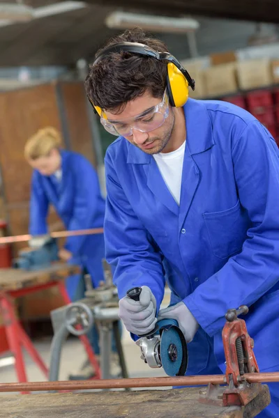Ученик с использованием циркулярной пилы в металлургическом цехе — стоковое фото