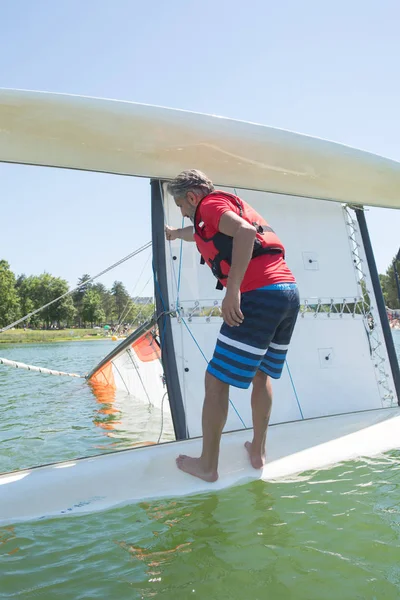 Salior trying to right his catamaran after capsize — Stock Photo, Image