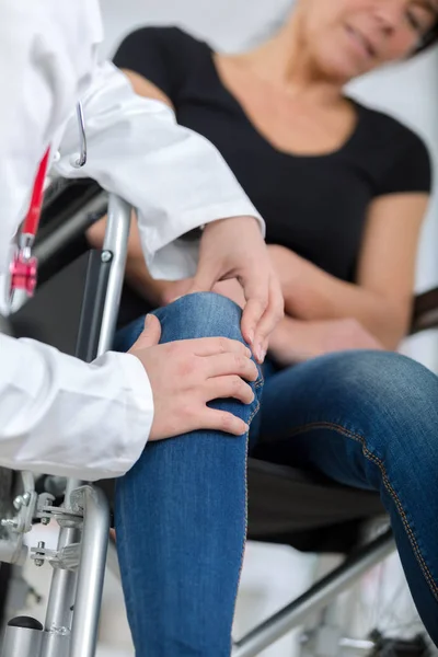 Male orthopedic doctor examining womans knee in clinic — Stock Photo, Image