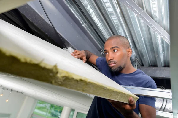 Young worker holding a plank — Stock Photo, Image