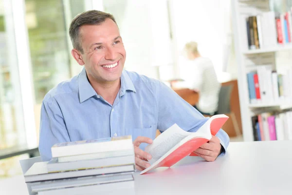 Escritor famoso sorrindo e biblioteca — Fotografia de Stock