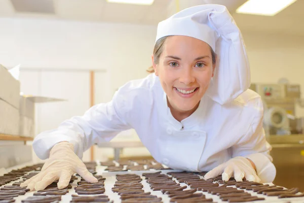 Chef inclinado através de chocolates — Fotografia de Stock