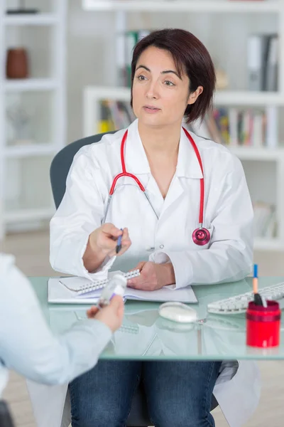 Mulher doente reclamando ao médico sobre os sintomas de mal-estar — Fotografia de Stock