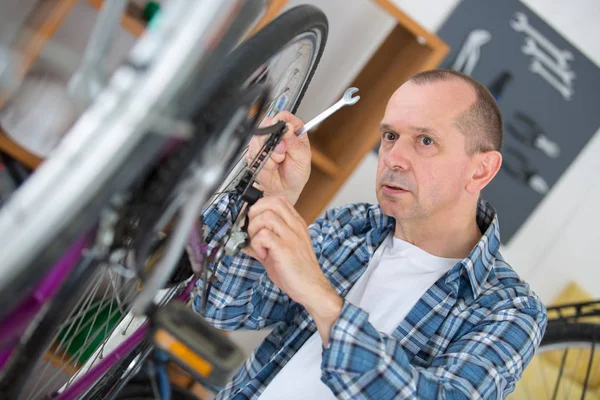 Geschäftsinhaber repariert Fahrrad — Stockfoto